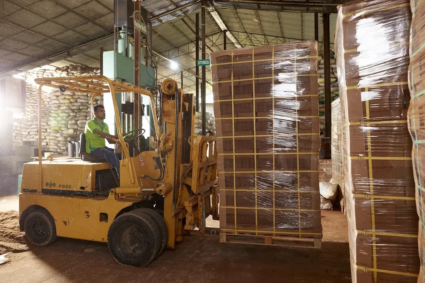 Forklift loading wrapped pallets of coco coir blocks at Avee Cocoseller's manufacturing facility in Tamil Nadu, India